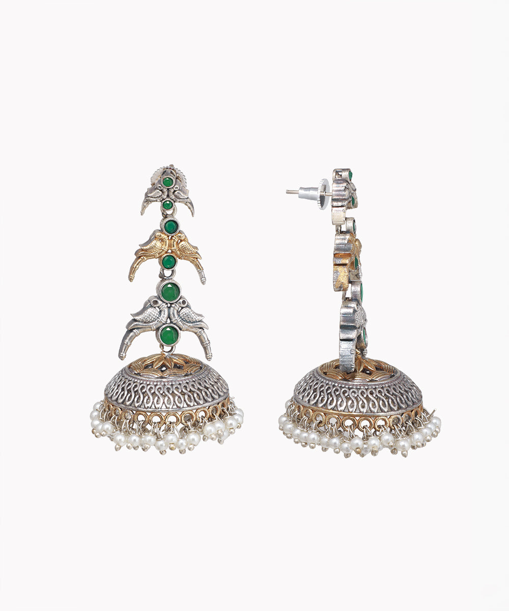 Ornate earrings with green gemstones and pearl-like elements on a white background