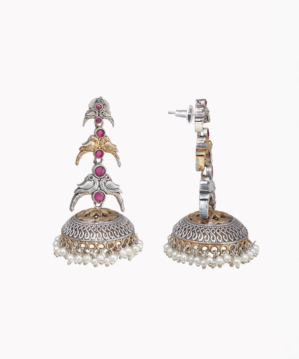 Ornate earrings with pink gemstones and pearl details on a white background