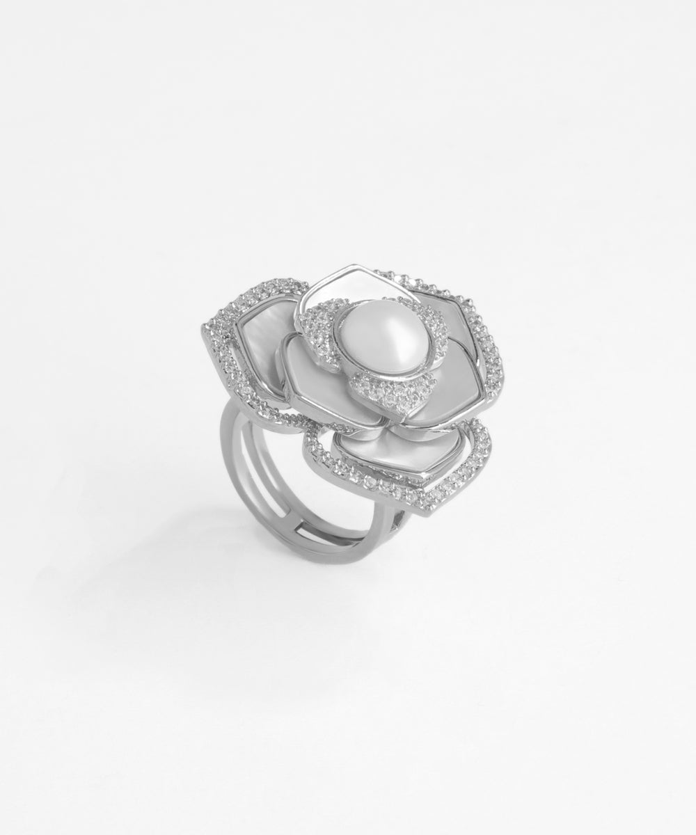 Silver ring with a pearl and diamond accents on a light gray background