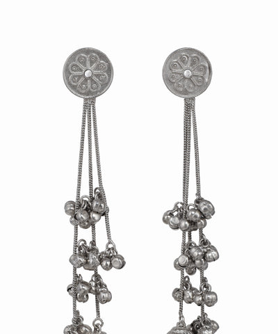 Silver earrings with intricate designs and dangling beads on a white background