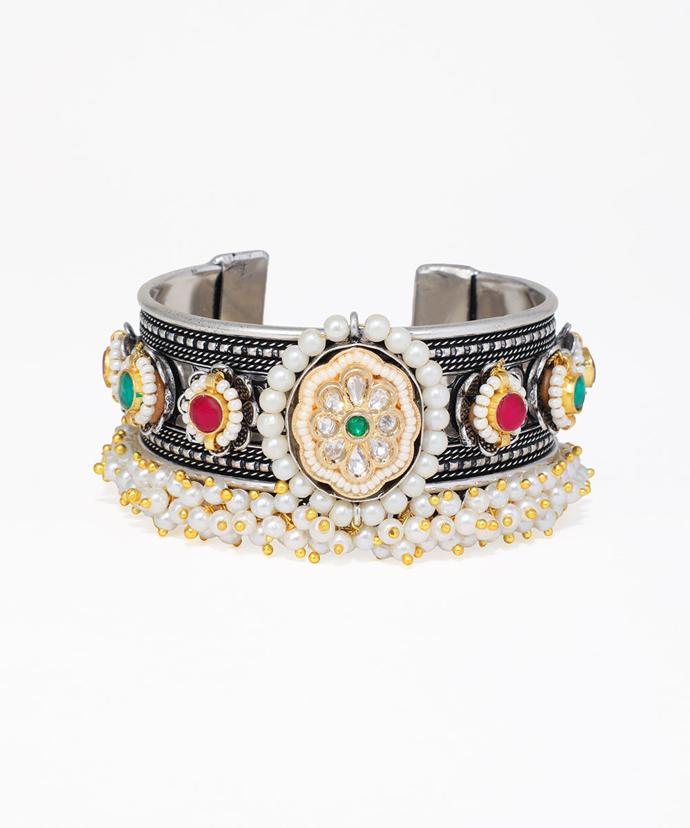 Decorative bracelet with metallic and gemstone details on a white background
