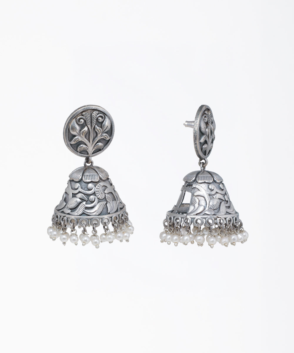 Oxidized finish jhumka earrings with intricate floral patterns and small faux pearl drops
