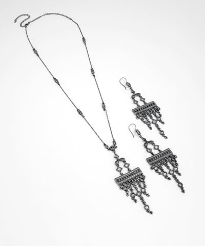 Silver necklace and earrings set on a white background