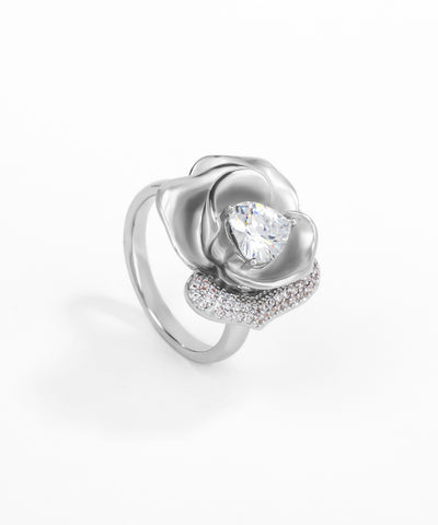Silver ring with a rose design and clear gemstone on a white background