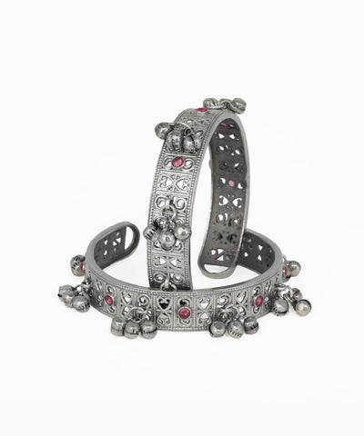 Silver bracelet with heart and round embellishments on a white background