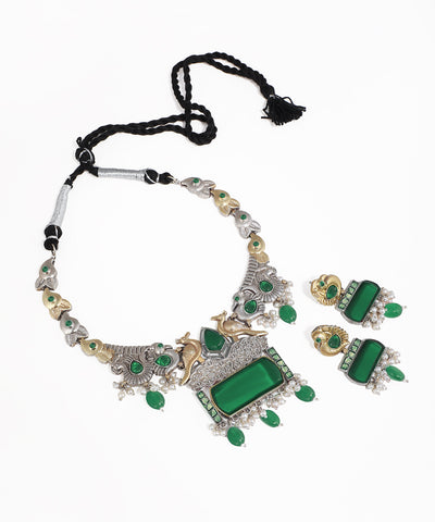 Jewelry set with necklace and earrings featuring green stones on a white background