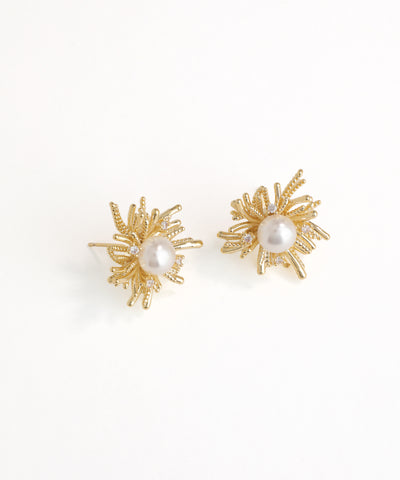 Gold earrings with pearl centers on a white background