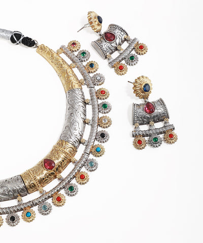 Ornate necklace and earrings with gemstones on a white background