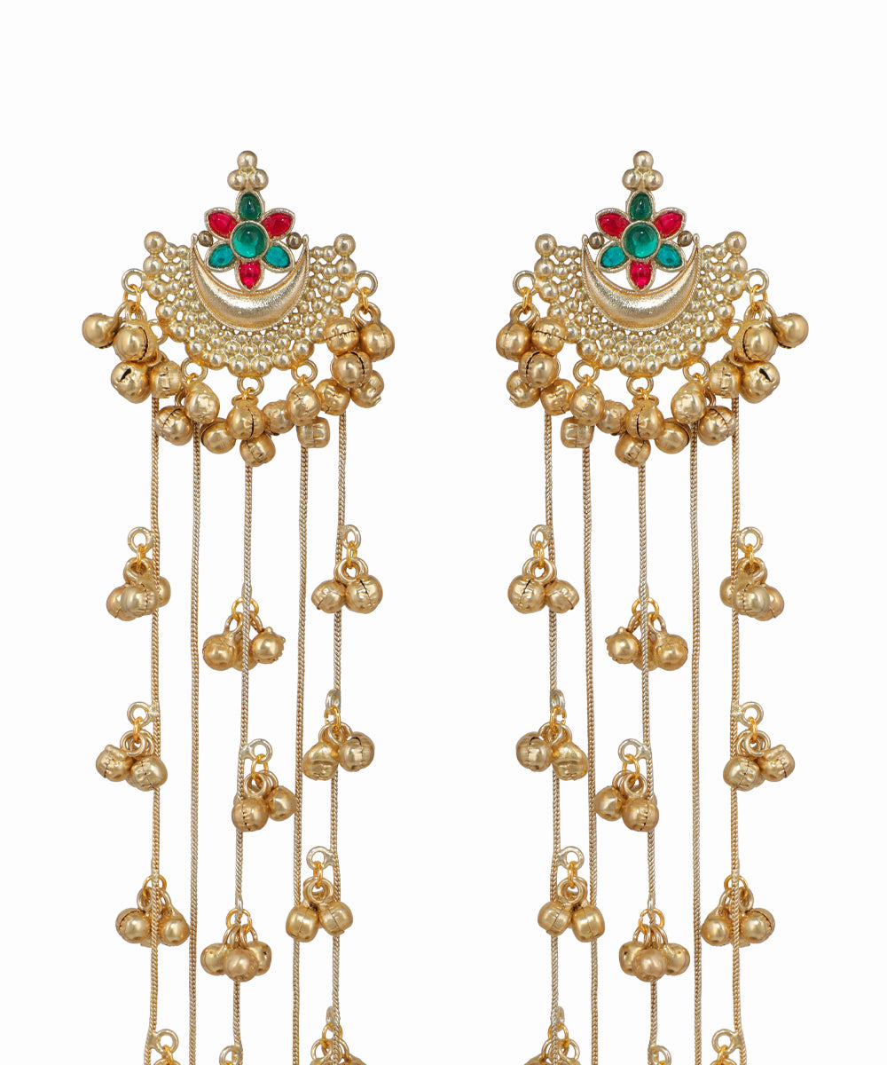 Pair of gold earrings with green and red gemstones on a white background