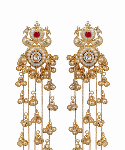 Ornate gold earrings with red gemstones on a white background