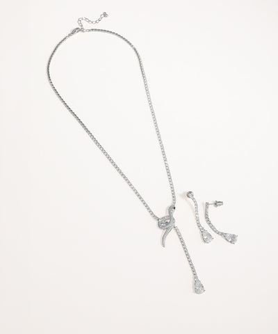 Silver necklace and earrings set on a light gray background