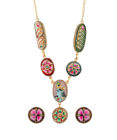 Gold-plated necklace and matching stud earrings featuring colorful, hand-painted enamel motifs including floral designs, paisley, and a central figure, set against a plain white background.