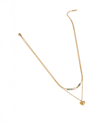 Gold necklace with heart pendant on a white background