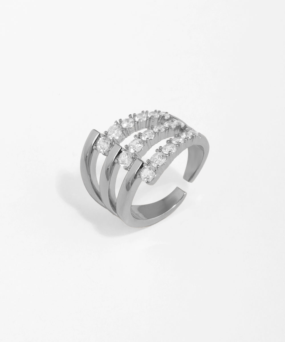 Silver ring with multiple rows of diamonds on a light gray background