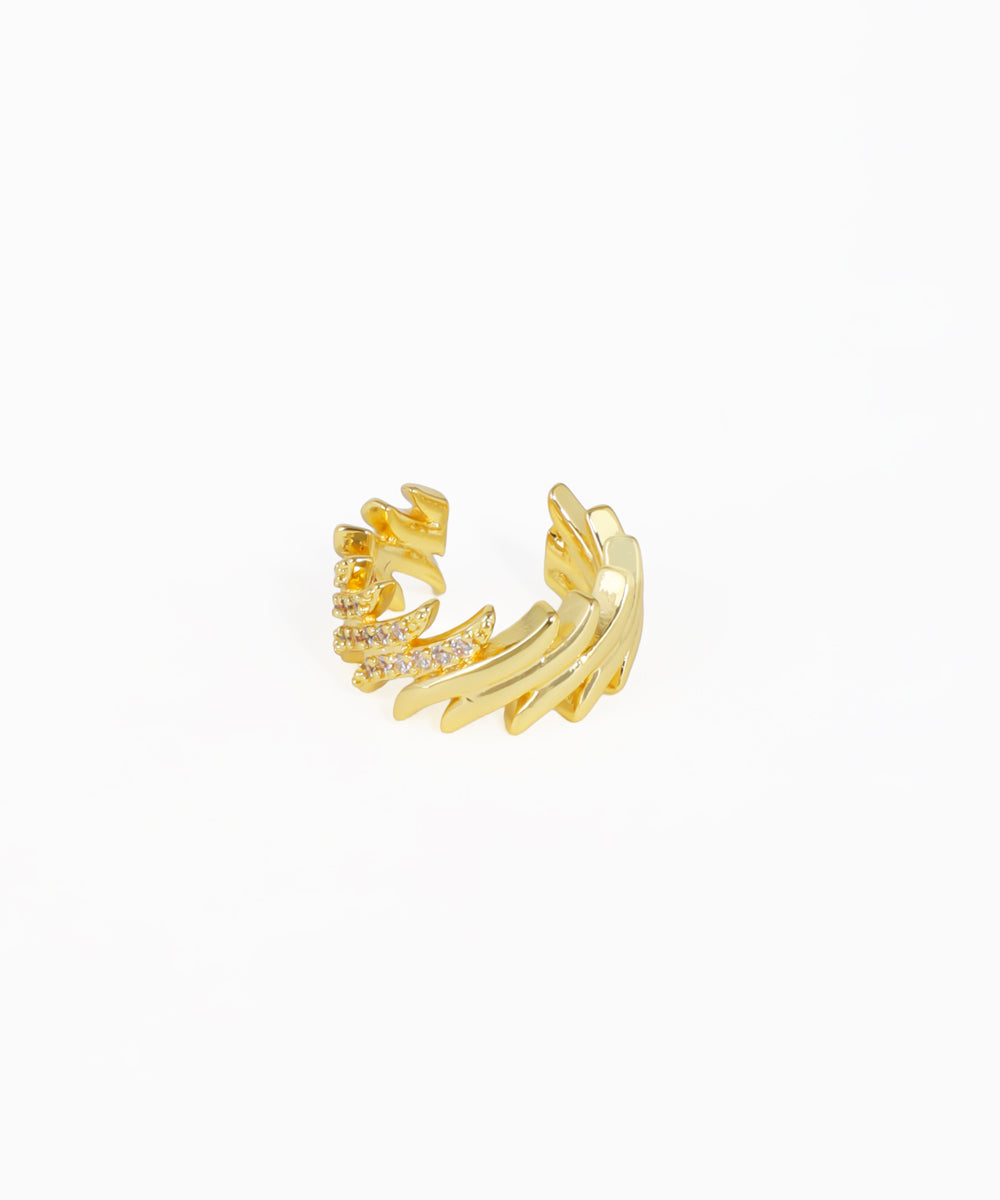Gold ear cuff with intricate design on a white background