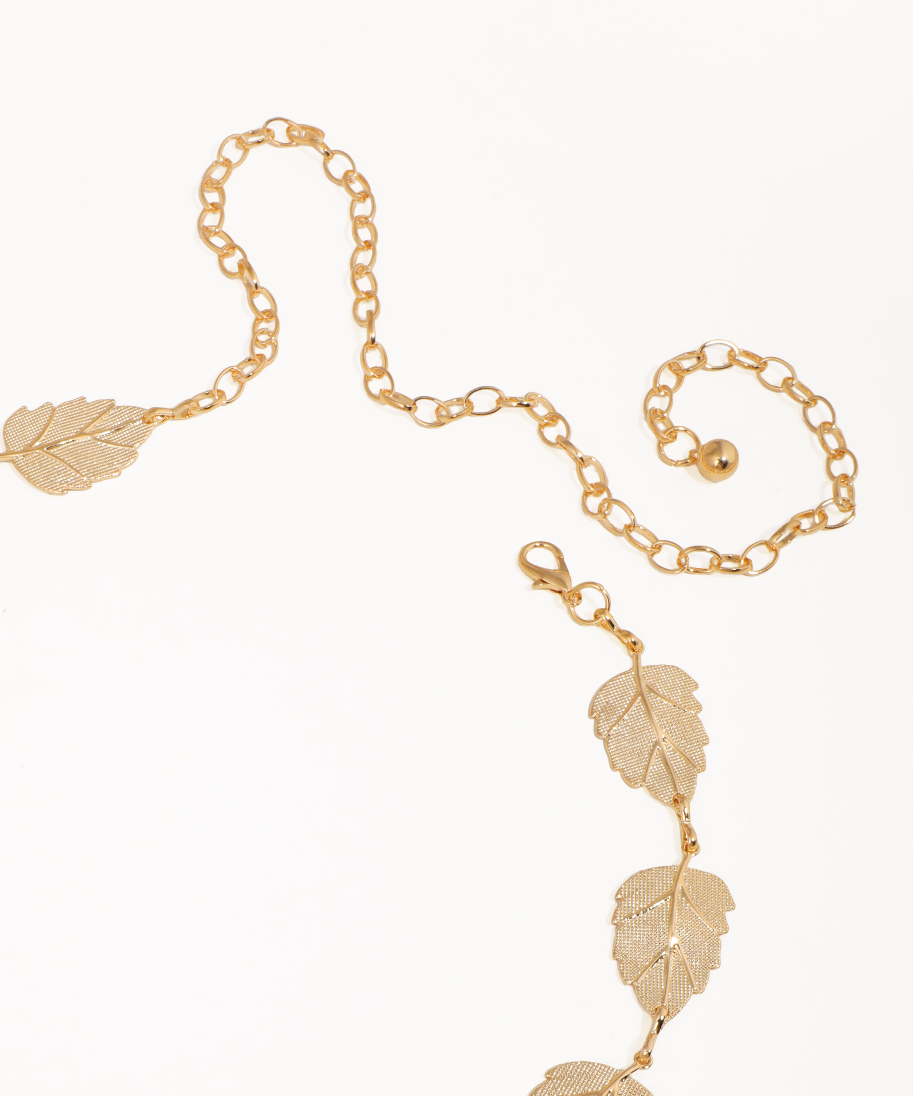Gold chain necklace with leaf pendants on a white background
