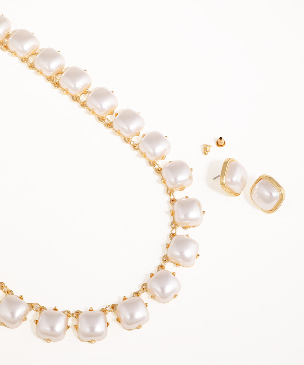 Pearl necklace and earrings set on a white background