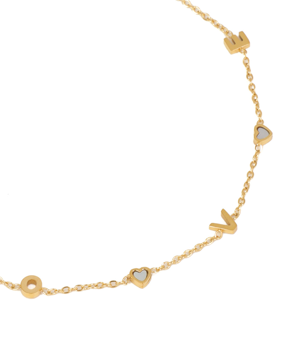Gold necklace with heart and circle pendants on a white background