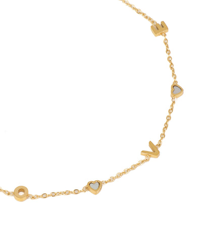 Gold necklace with heart and circle pendants on a white background