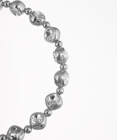 Silver bracelet with clear gemstones on a white background