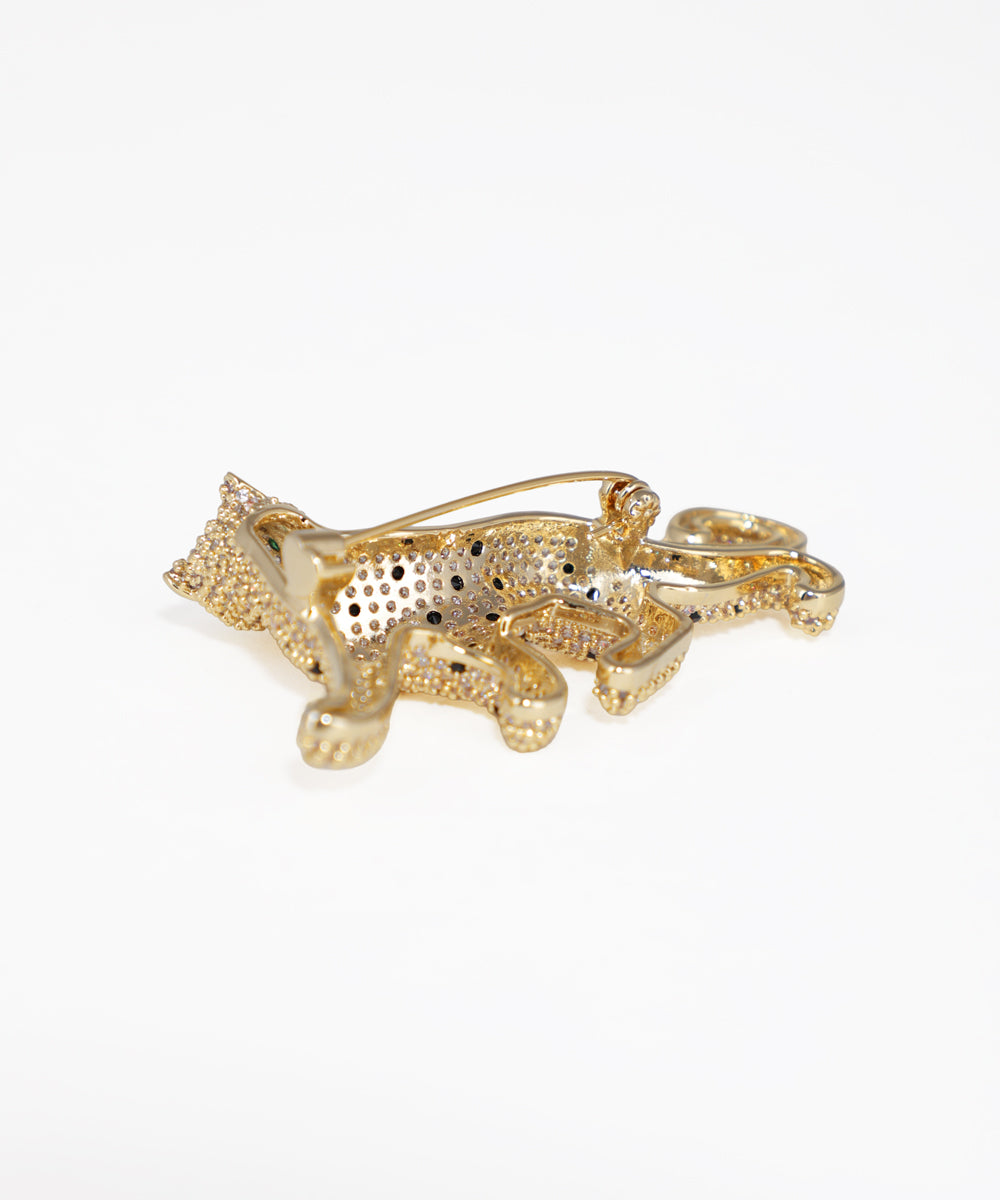 Gold animal-shaped brooch on a white background