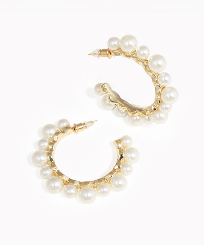 Gold hoop earrings with pearl accents on a white background
