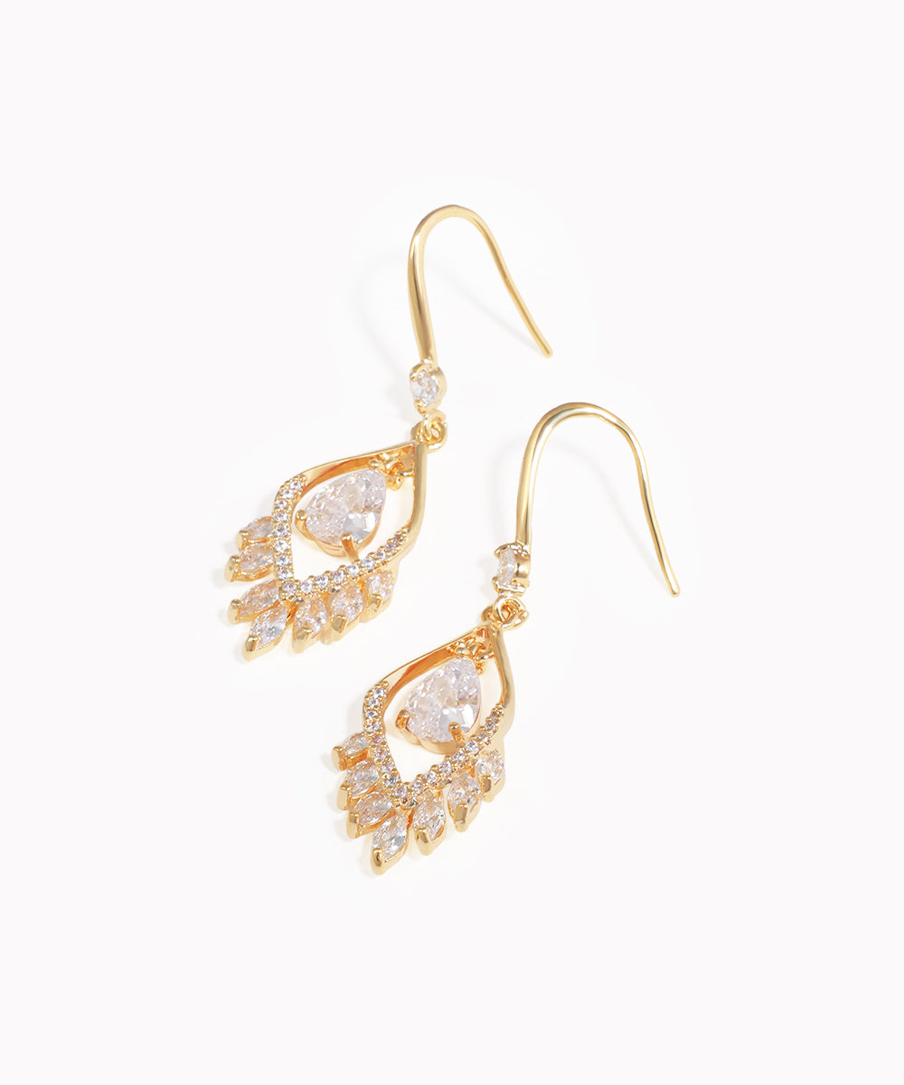 Gold earrings with clear gemstones on a white background