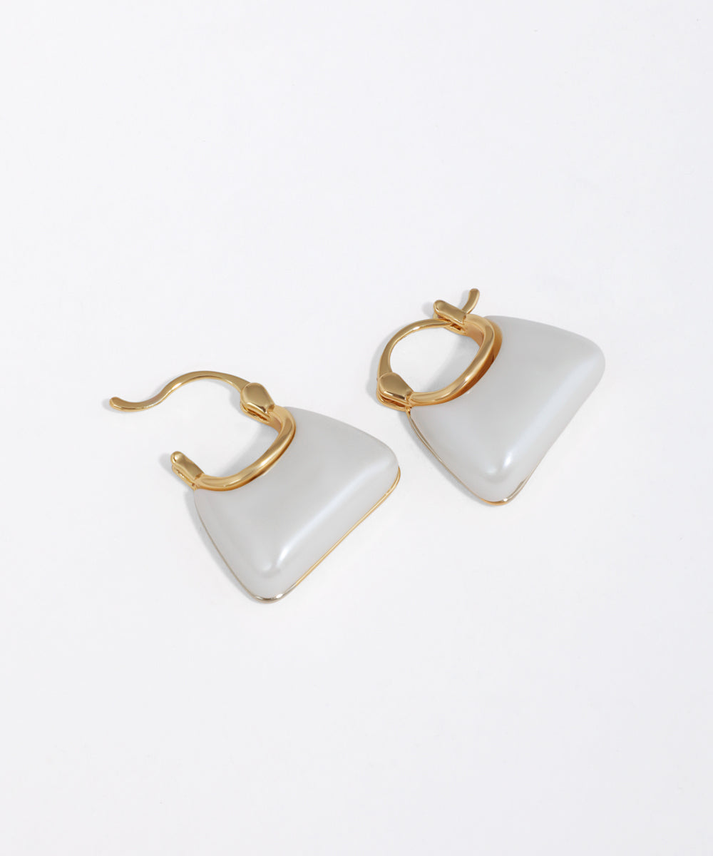 Pair of triangle-shaped bag shaped earrings with gold accents on a white background