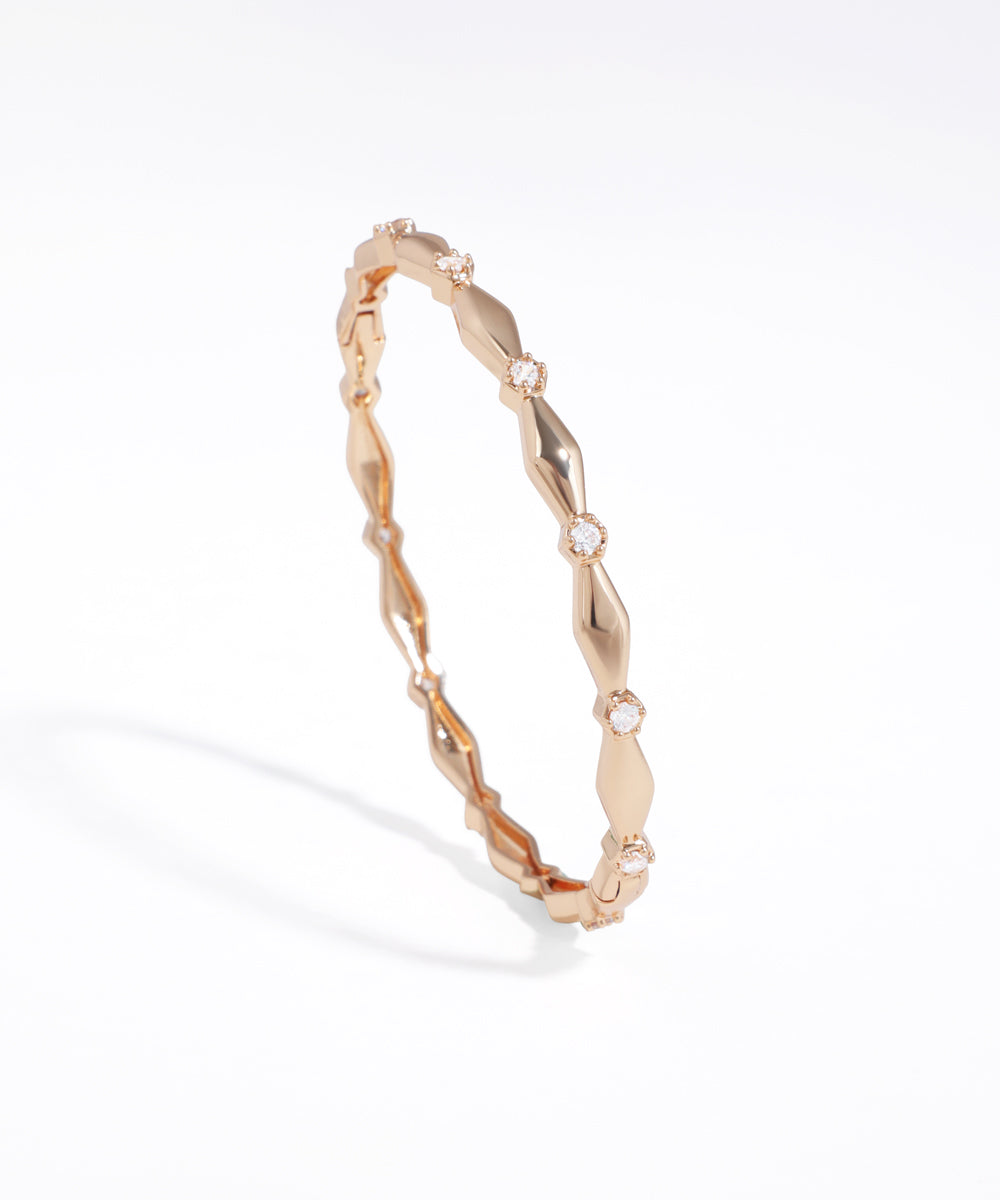 Rose gold bracelet with diamond accents on a white background