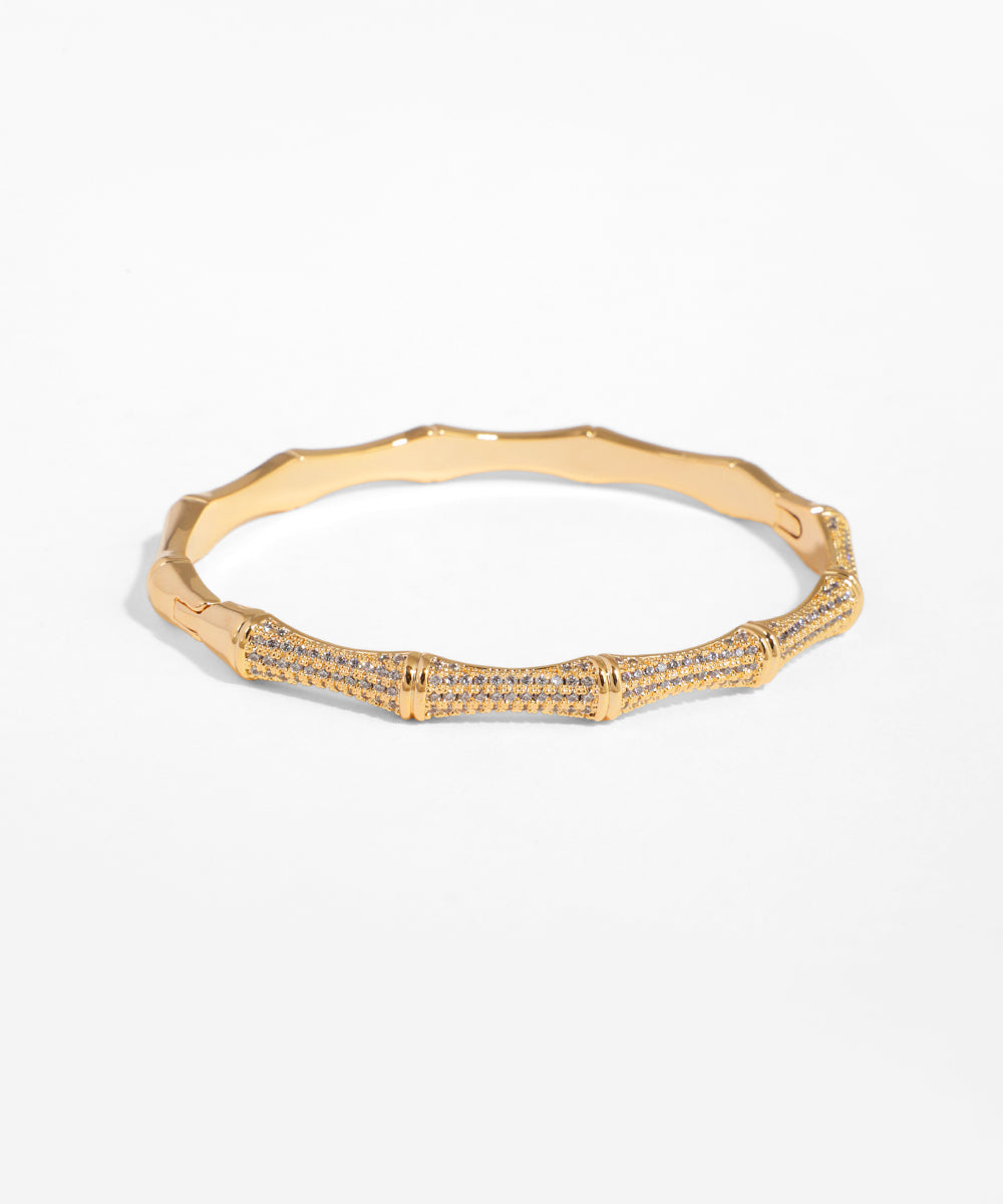 Gold bracelet with diamond accents on a white background