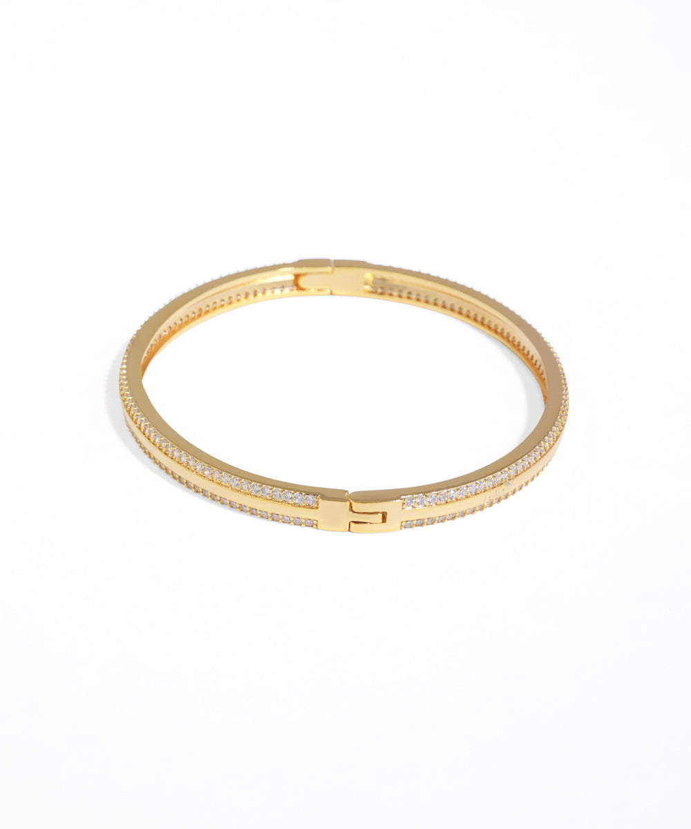 Gold bracelet with embedded stones on a white background