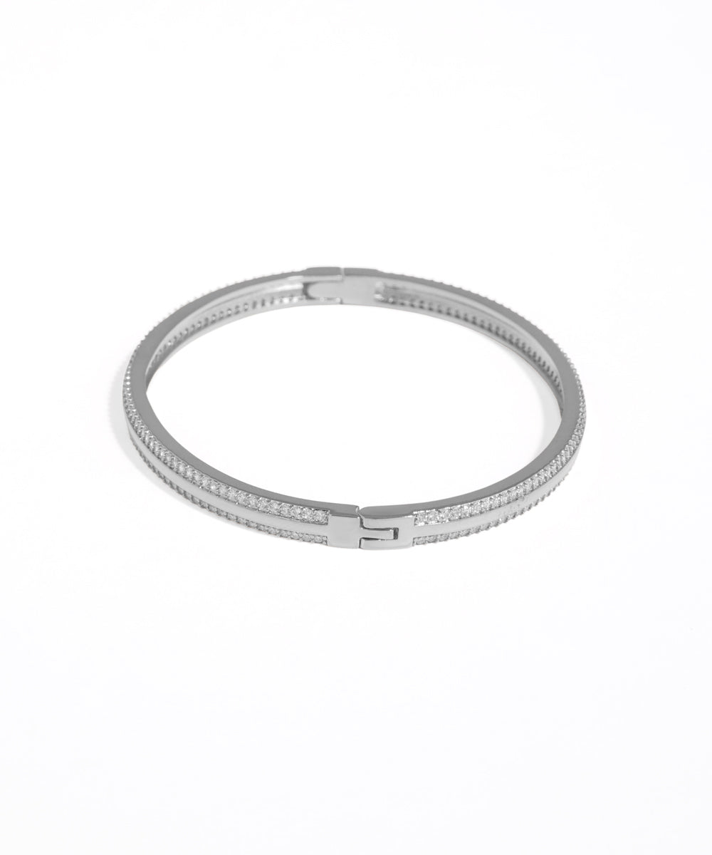 Silver bracelet with clear stones on a white background