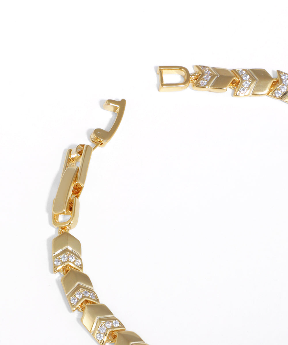 Gold bracelet with diamond accents on a white background