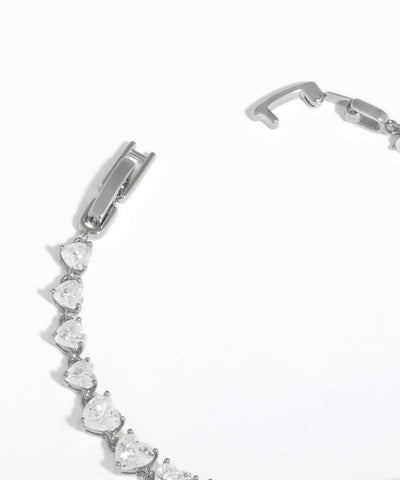 Silver bracelet with heart-shaped gemstones on a white background