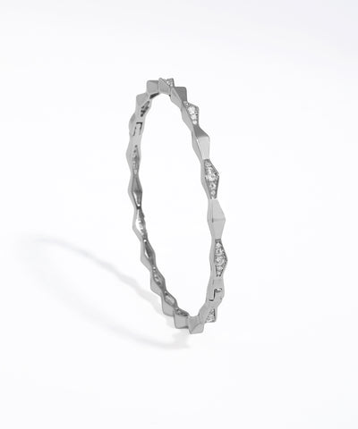 Silver ring with a wavy design on a white background
