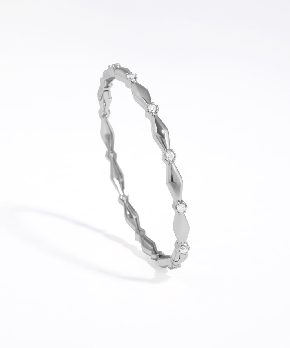 Silver bracelet with a subtle design on a white background