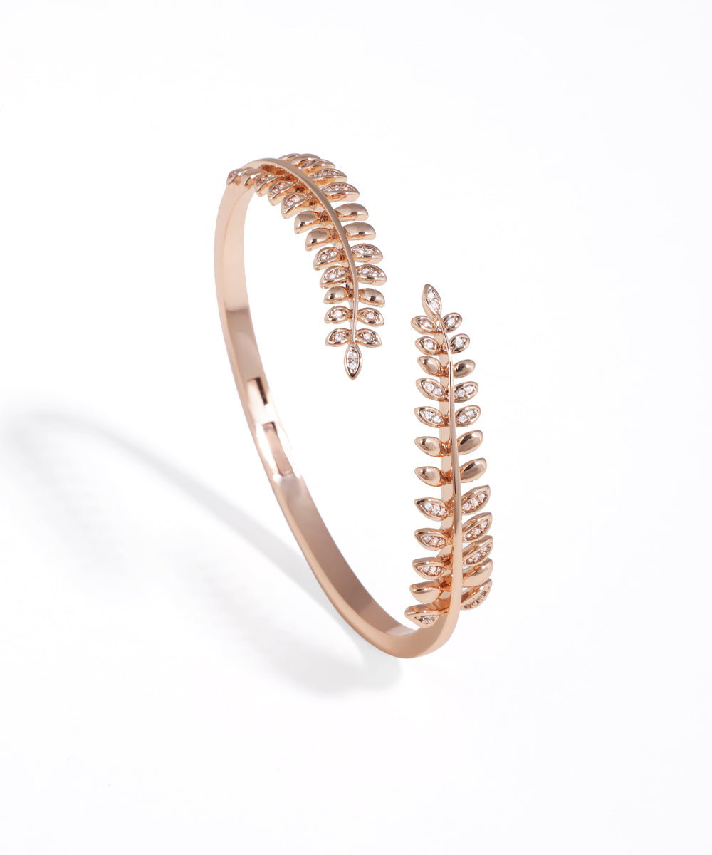 Rose gold bracelet with leaf design on a white background