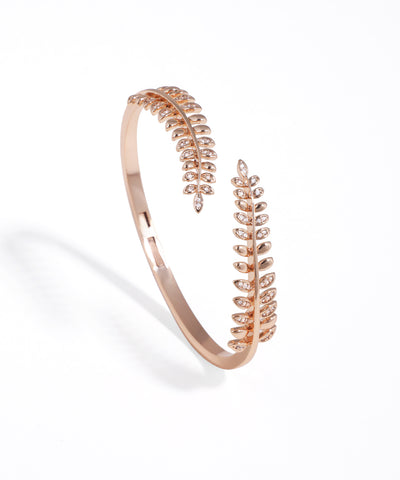 Rose gold bracelet with leaf design on a white background
