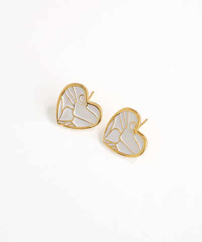 Gold and white butterfly-shaped earrings on a light beige background