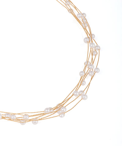 Multi-strand pearl necklace with gold accents on a white background