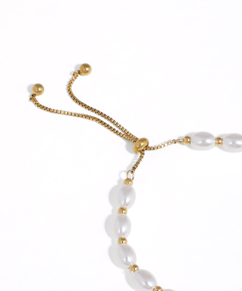 Pearl bracelet with gold accents on a white background