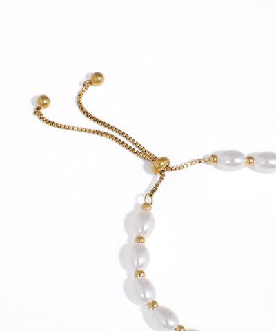 Pearl bracelet with gold accents on a white background