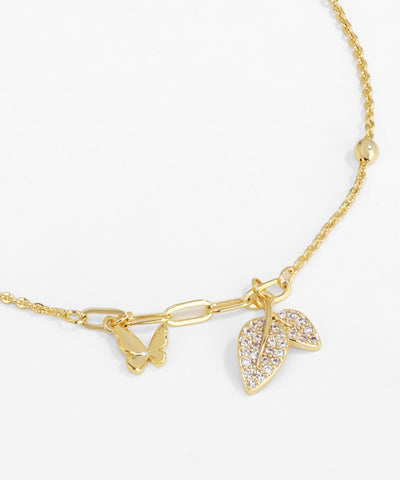 Gold necklace with leaf-shaped pendant on a white background