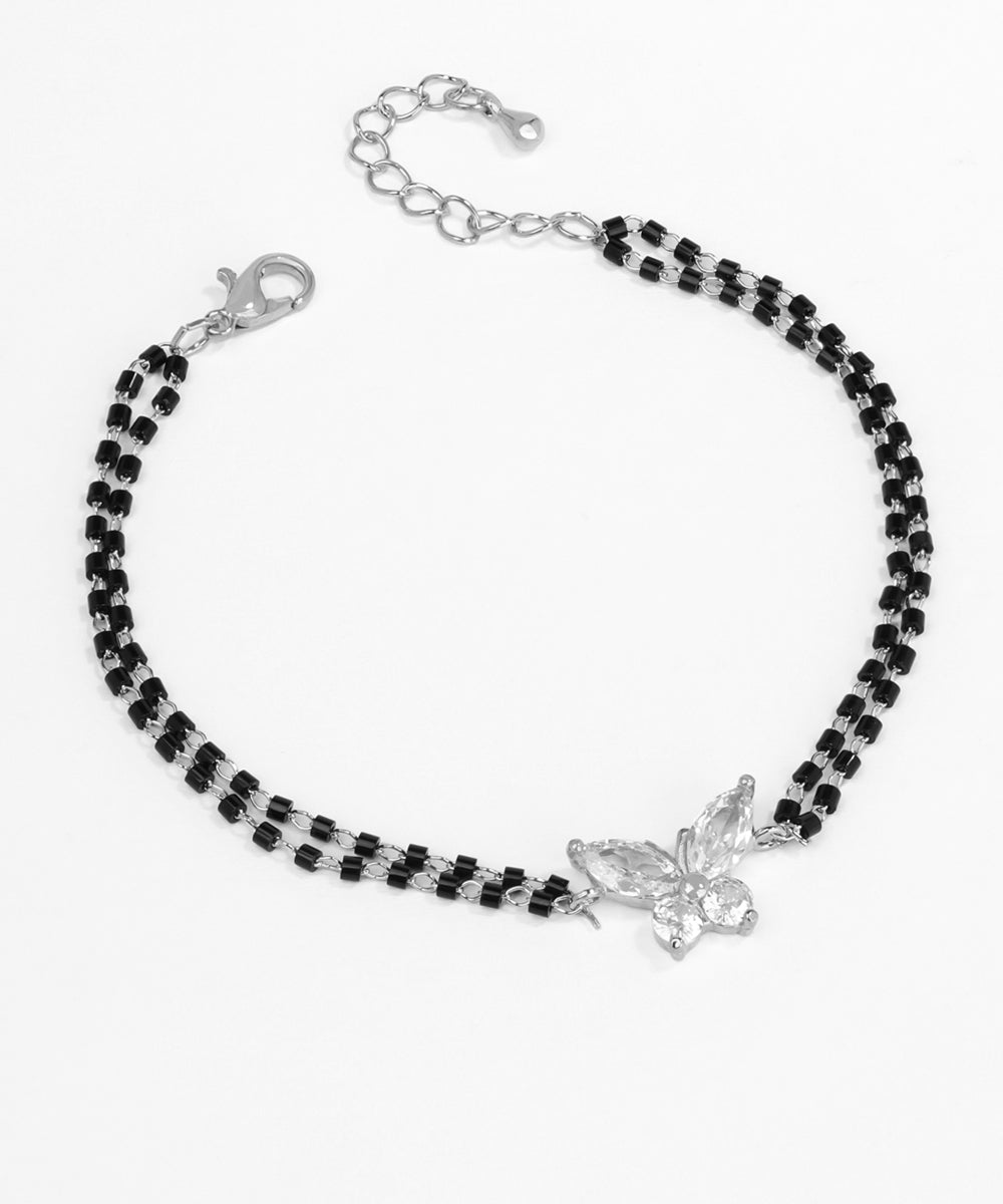 Black beaded bracelet with a silver butterfly charm on a white background
