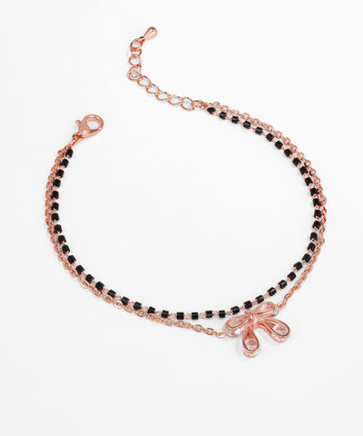 Rose gold bracelet with black beads on a white background
