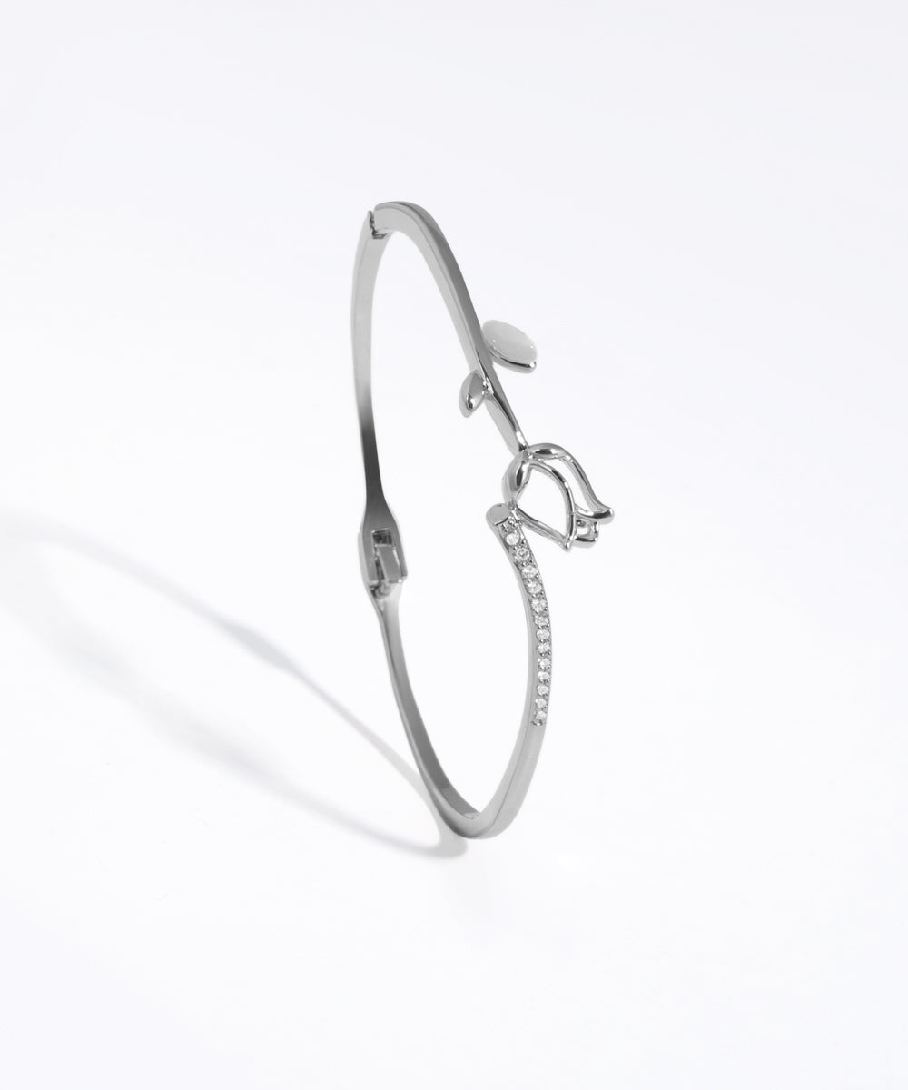 Silver bracelet with bow design on a white background
