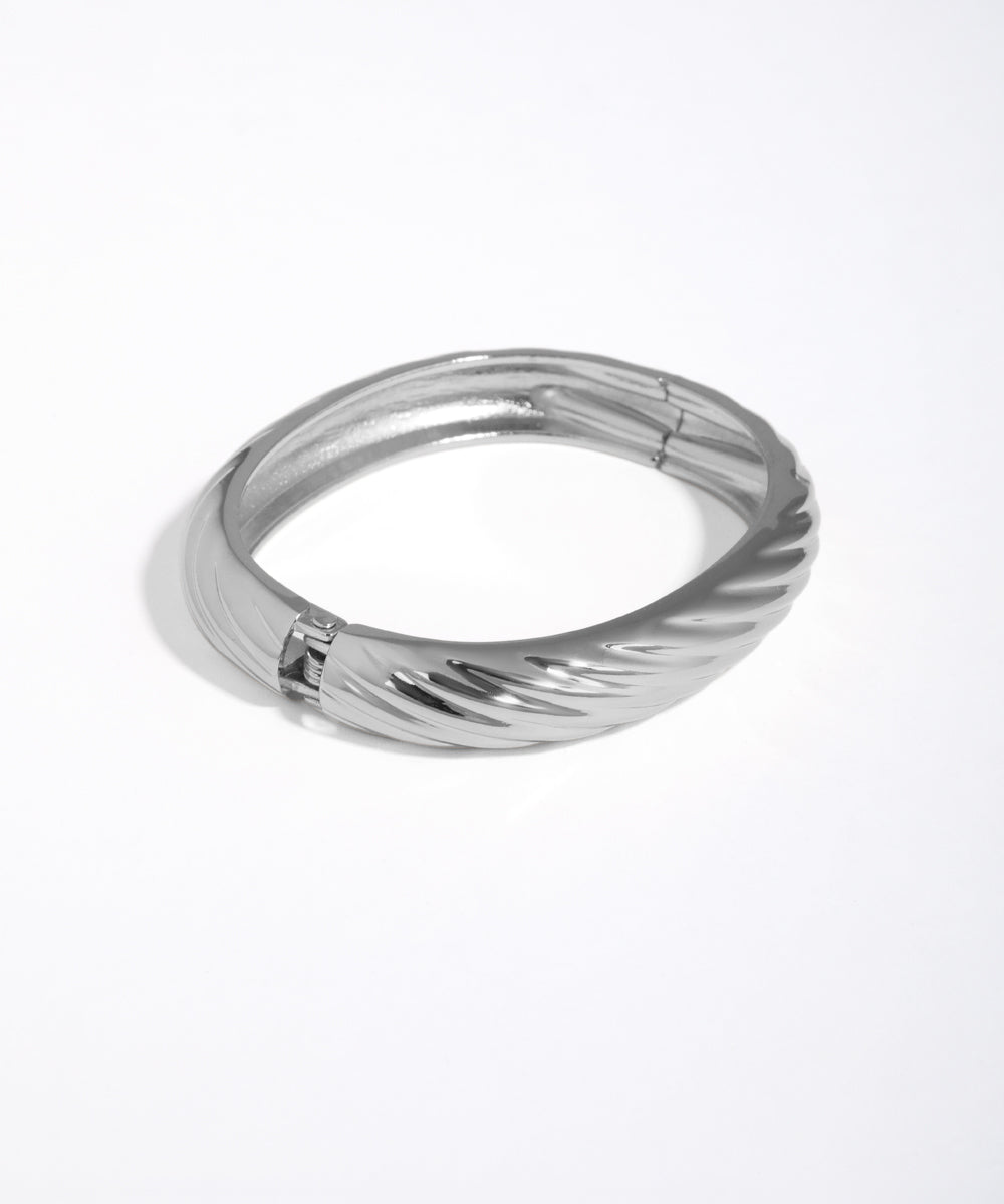 Silver ring with a textured design on a white background