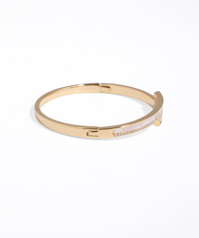 Gold bangle with pink interior on a white background