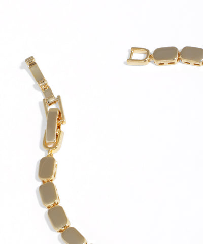 Gold bracelet with geometric links on a white background