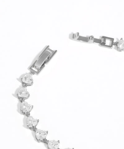 Silver bracelet with clear gemstones on a white background